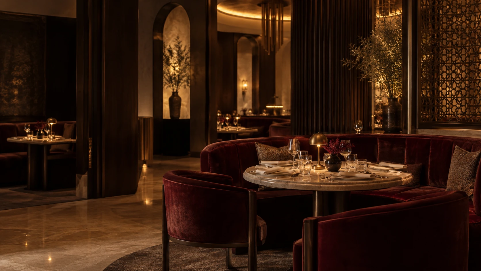 Elegant dining lounge with burgundy velvet, dark wood and warm brass lighting